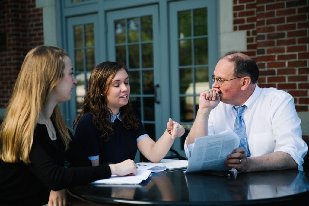 Professor discussing a paper with students